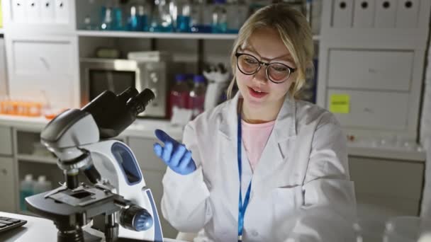 Een Jonge Blonde Vrouw Onderzoekt Specimens Onder Een Microscoop Een — Stockvideo