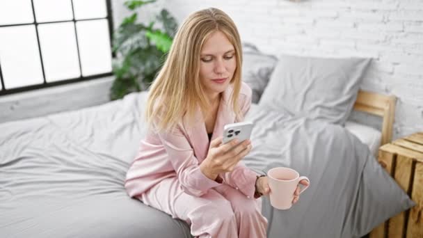 Mladá Žena Pyžamu Relaxuje Kávou Smartphonem Své Moderní Ložnici — Stock video