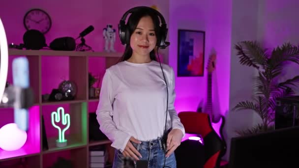 Kulaklıklı Neşeli Asyalı Genç Bir Kadın Gece Canlı Bir Oyun — Stok video