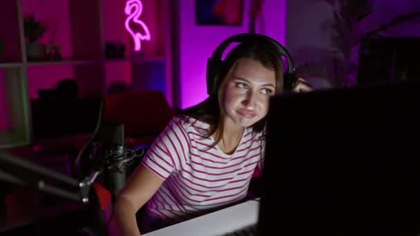 Молода Біла Жінка Навушниками Сидячи Приміщенні Вночі Неоновому Освітленому Ігровому — стокове відео