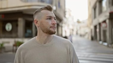 Sakallı beyaz adam, caddede gülümsüyor.