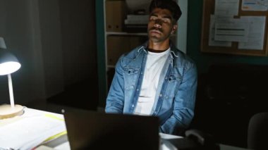 Sakallı genç İspanyol adam gece geç saatlerde ofiste yoruldu.