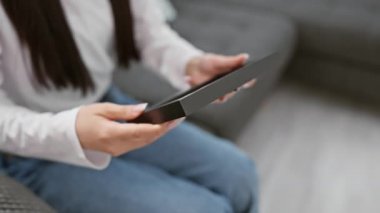 Evde tablet kullanan genç bir Asyalı kadın, her gün evde yaşananları yansıtıyor..