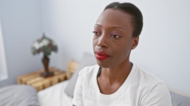 晕头转向的非洲裔美国女人躺在床上 满嘴怀疑的表情 在卧室里露出讽刺的表情 — 图库视频影像
