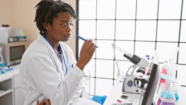 Uma Jovem Cientista Africana Ponderando Laboratório Com Microscópio Produtos Químicos — Vídeo de Stock