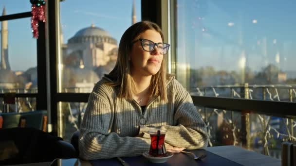 Улыбающаяся Женщина Очках Наслаждается Чаем Видом Агиа Софию Ресторане Istanbul — стоковое видео