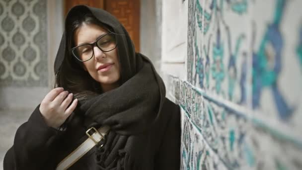 メガネの美しい若い女性 イスタンブールのオスマン時代のタイル張りの壁に暖かく笑顔 文化と観光を展示 — ストック動画