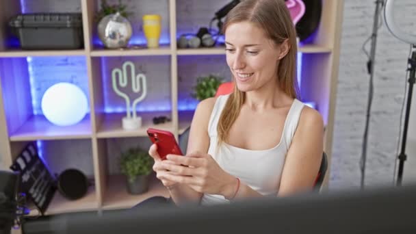 Lächelnde Junge Frau Mit Smartphone Einem Modernen Neonbeleuchteten Spielzimmer — Stockvideo
