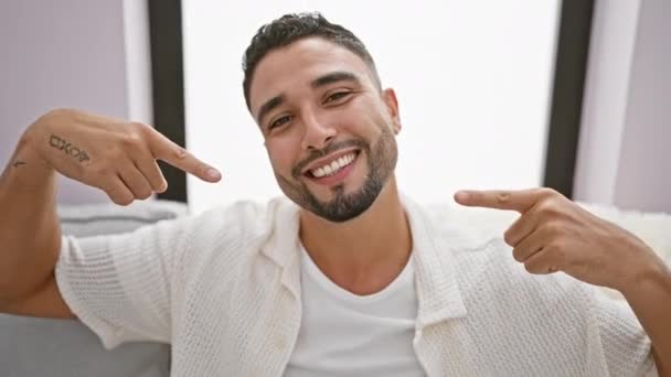 Ein Fröhlicher Junger Arabischer Mann Sitzt Gemütlich Auf Seinem Heimischen — Stockvideo