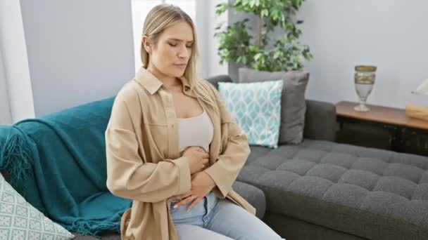 Mujer Rubia Joven Preocupada Que Sufre Dolor Estómago Sentado Sofá — Vídeos de Stock