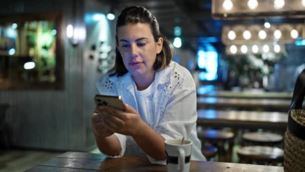 Όμορφη Νεαρή Ισπανίδα Γυναίκα Που Χρησιμοποιεί Smartphone Χαμογελώντας Στην Καφετέρια — Αρχείο Βίντεο