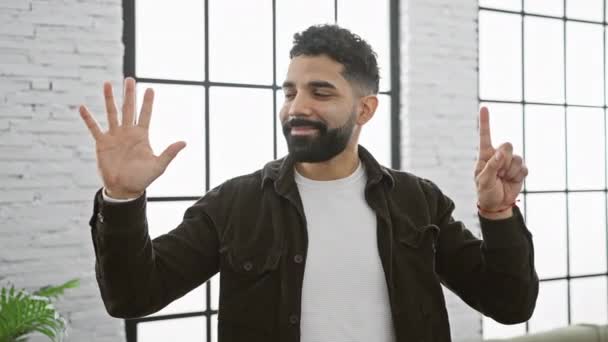 Veselý Sebevědomý Mladý Muž Radostně Ukazuje Šestku Prsty Zatímco Doma — Stock video