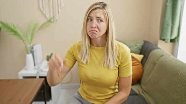 一个不确定的金发女人在思考着一个令人怀疑的问题 在家里穿着一件T恤衫沉思着 一幅混乱和惊奇的概念图 — 图库视频影像