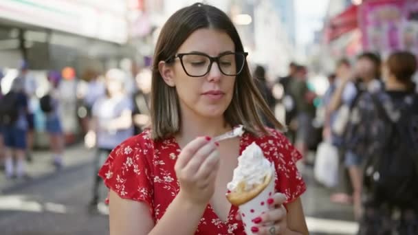 안경을 화려한 히스패닉 여성은 도쿄의 번화한 타케시타 거리에 맛있는 아이스크림을 — 비디오