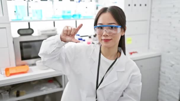 과학자 아름답고 자신감 그녀의 실험실에서 손가락으로 기호를 제스팅 — 비디오
