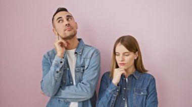 Kot gömlekli güzel bir çift, çenelerini uzatıyorlar, bir soru üzerine düşüncelere dalmışlar. Pembe arka plana karşı yüzlerindeki şüpheli gülümseme.