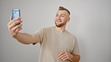 Yakışıklı bir adam selfie çekiyor. Gülümsüyor. Sıradan, izole beyaz bir arka plan.