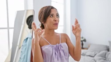 Pijamalı, umut dolu genç bir İspanyol kadın. Yatakta parmakları çapraz, gözleri kapalı, rahat yatak odasında şans diliyor..