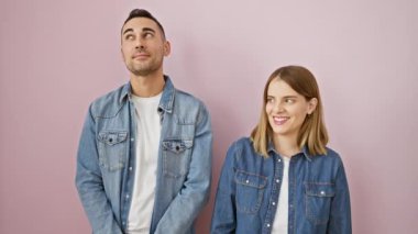 Gülümseyen, düşünen kot gömlek giyen, kendine güvenen bir çift. Güzel gözleri aşkı ve güveni yansıtır. Pembe izole arka planda birlikte dururlar..