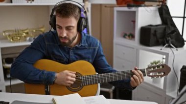 Yetenekli genç İspanyol adam samimi müzik stüdyosunda klasik gitarla melodik bir şarkı bestelemeye daldı.