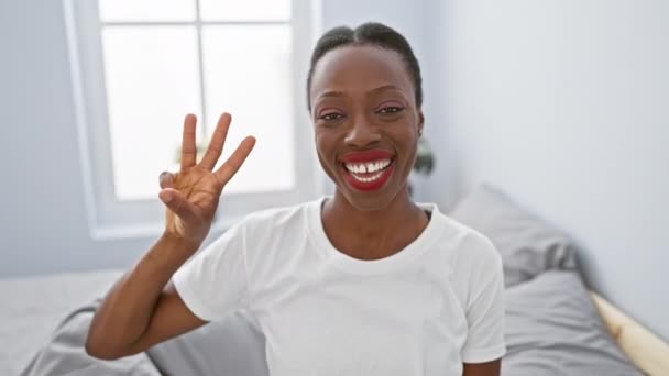 Χαρούμενη Αφρο Αμερικανίδα Γυναίκα Που Δείχνει Παιχνιδιάρικα Τρία Δάχτυλα Ξαπλωμένη — Αρχείο Βίντεο