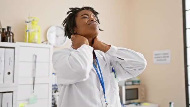 一个年轻的黑人女人 在诊所痛苦地挽着她的脖子 — 图库视频影像