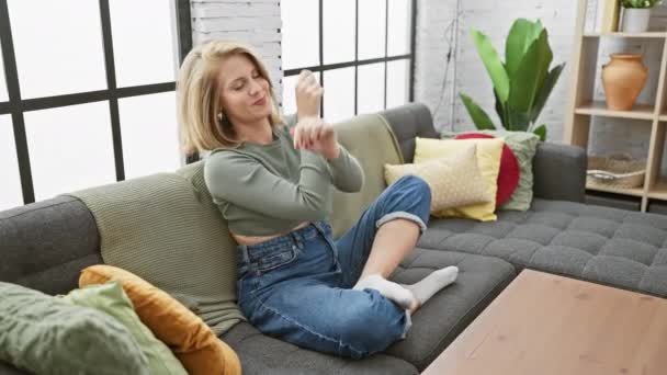 Une Femme Satisfaite Assise Sur Canapé Dans Salon Confortable Étire — Video