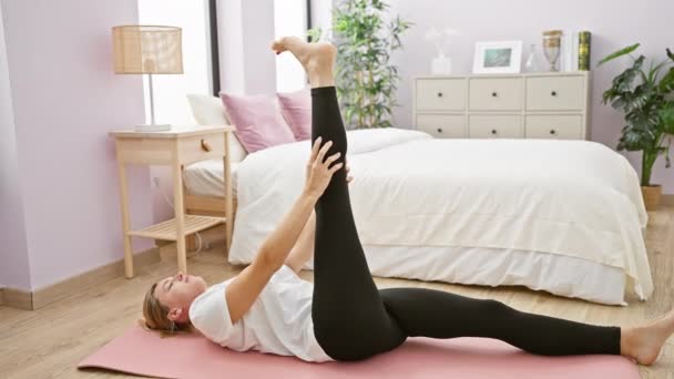 女性は彼女の平和な寝室でヨガを実践し 健康と運動のための穏やかな環境を作成します — ストック動画