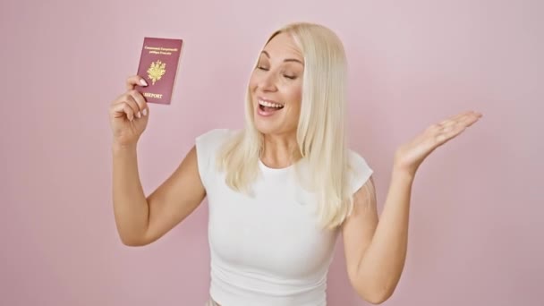 胜利了 胜利了 年轻貌美的金发女子欢欢喜喜地举着法国护照 庆祝签证的批准 在孤立的粉色背景画像中兴奋的溢出 — 图库视频影像