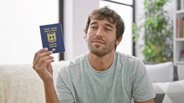 Joven Barbudo Confiado Alegre Mostrando Pasaporte Israelí Sentado Casualmente Sofá — Vídeo de stock