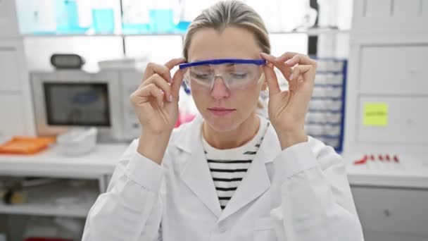 Μια Γυναίκα Επιστήμονας Ένα Εργαστήριο Εξετάζει Προστατευτικά Γυαλιά Αντιπροσωπεύει Τον — Αρχείο Βίντεο
