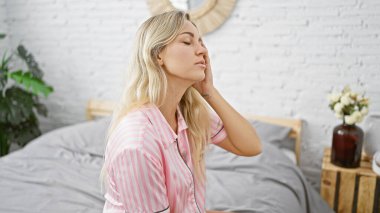 Huzurlu bir kadın yatak odasında dinleniyor, sükuneti ve sabah şıklığını somutlaştırıyor..