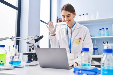 Young caucasian woman scientist having video call at laboratory