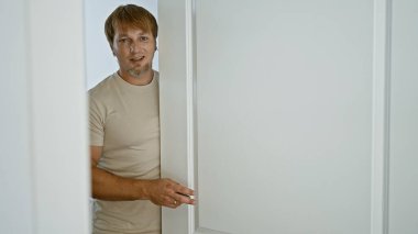 Sakallı ve sarı saçlı gülümseyen beyaz bir adamın portresi..