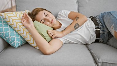 Young woman lying on sofa sleeping at home
