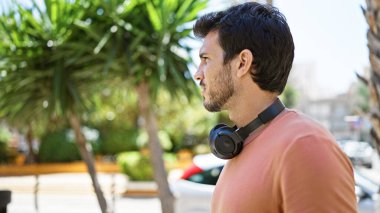 Yakışıklı, sakallı, şehir dışında kulaklıkla müzik dinleyen bir İspanyol..