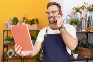 Çiçekçide konuşan orta yaşlı bir çiçekçi.