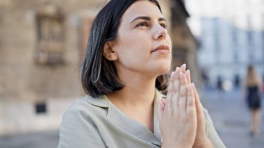 Genç ve güzel İspanyol kadın gülümseyerek Viyana sokaklarında dua ediyor.