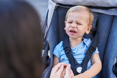 Anne ve oğlu bebek arabasında oturup sokakta ağlıyorlar.