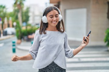 Sokak ortasında müzik dinleyen ve dans eden genç, güzel İspanyol kadın.