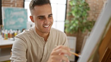 Parlak bir sanat stüdyosunda resim yapan yakışıklı bir İspanyol.