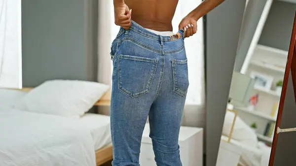 African american woman wearing jeans standing backwards at bedroom