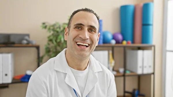 一位面带微笑的惊慌男子穿着一件白色的实验室外套 摆出一副康复诊所的样子 — 图库照片