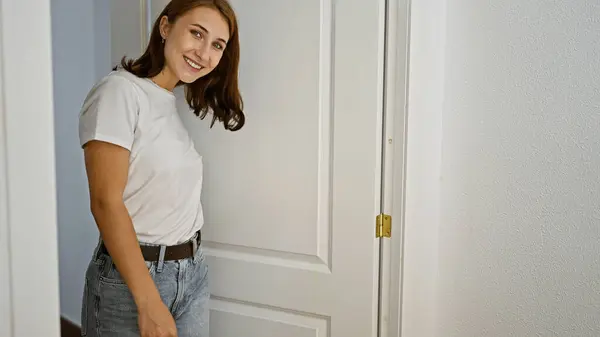 Młoda Kobieta Otwiera Drzwi Uśmiechając Się Domu — Zdjęcie stockowe