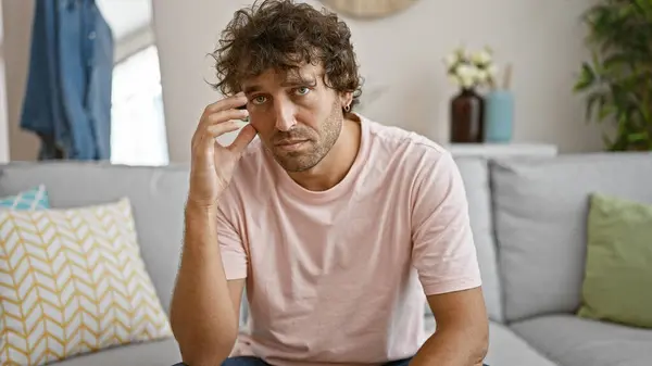 Thoughtful Young Hispanic Man Sits Grey Couch Cozy Living Room — Stock Photo, Image