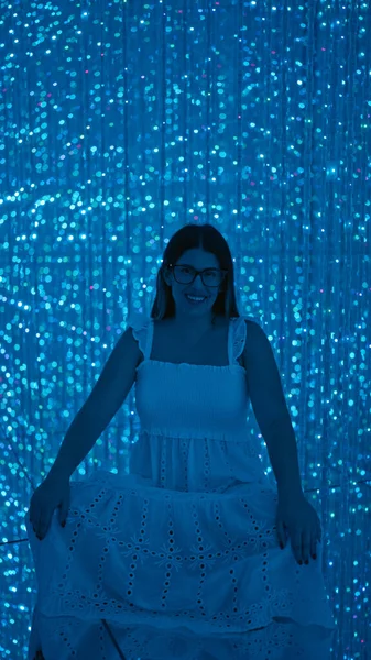 Gülümseyen güzel İspanyol kadın modern müzede fütürist sergiler sergiliyor. Lazerler, ışıklar, en iyi yenilikler.!