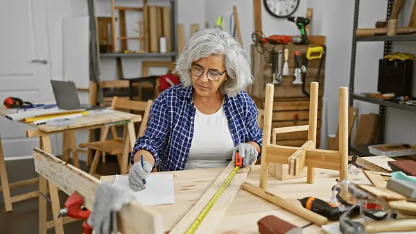 Mature Woman Measuring Wood Tape Cluttered Carpentry Workshop — Stock Photo, Image