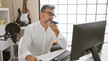 Yakışıklı, İspanyol asıllı, kır saçlı, haber spikeri. Samimi radyo stüdyosunda akıllı telefon mesajı yolluyor.