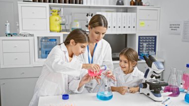 Bir kadın ve genç bir kız bir bilim laboratuarında deney yapıyorlar.