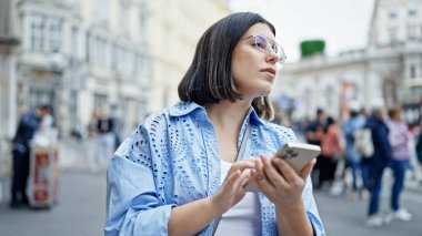 Viyana sokaklarında taksi bekleyen akıllı telefon kullanan genç, güzel İspanyol kadın.